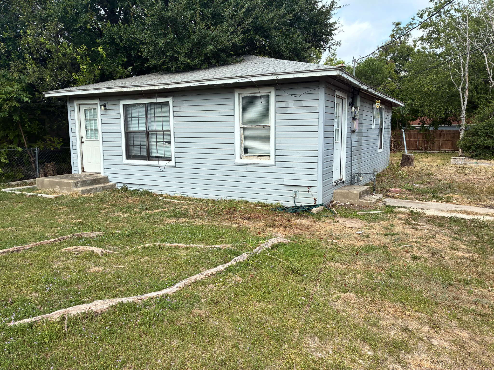 After property recovery: cut grass and cleared ground beside the same house
